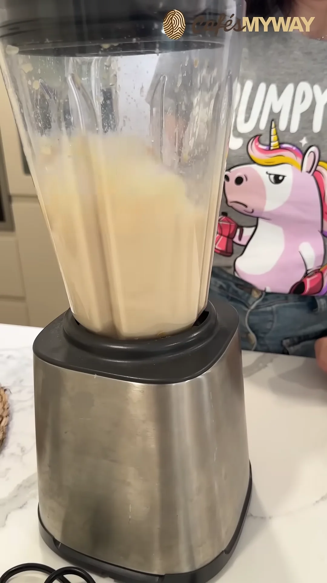 Café con plátano, leche y hielo mezclándose en la batidora