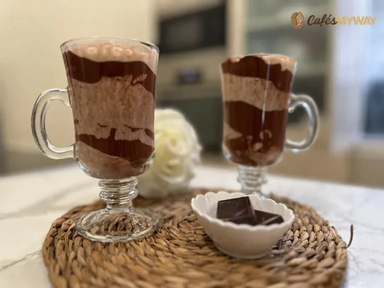 Café con plátano y chocolate servido en dos vasos decorados con cacao