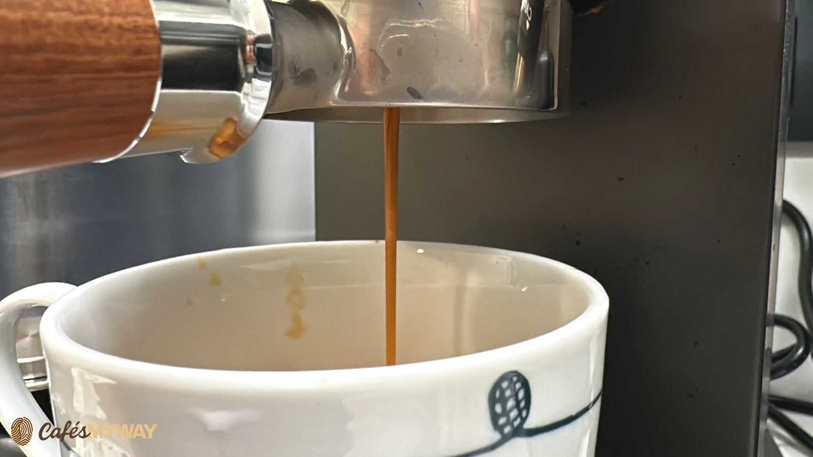 Café saliendo del portafiltro hacia un recipiente blanco