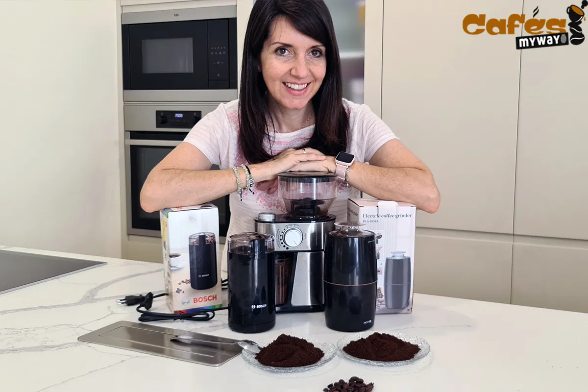 Varios molinillos eléctricos y platos con café molido sobre una encimera
